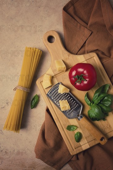 Raw pasta with ingredients on a beige background, top view, rustic style, selective focus, no people.