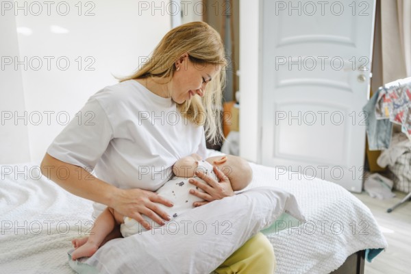 A serene scene of a mother lovingly breastfeeding her baby on a comfortable bed. The bright room and affectionate bond emphasize maternal care and nurture