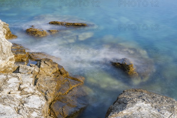 Crystal clear and turquoise water on the beach of Ustrine Bay on a sunny day on the island of Cres, long exposure, Croatia