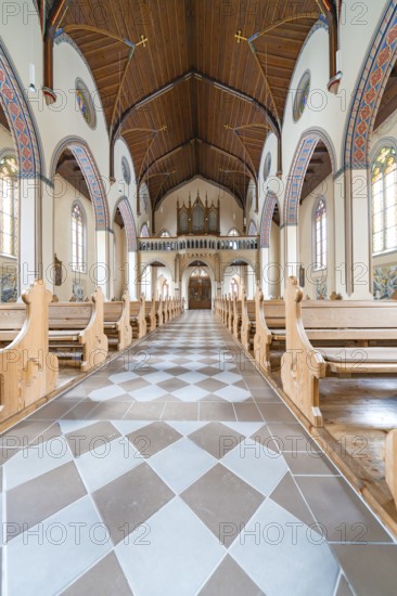 Long aisle in a church with elegant wooden benches and artistically decorated structure, Bad Wildbad, St.Bonifatius, Catholic parish, Black Forest, Germany