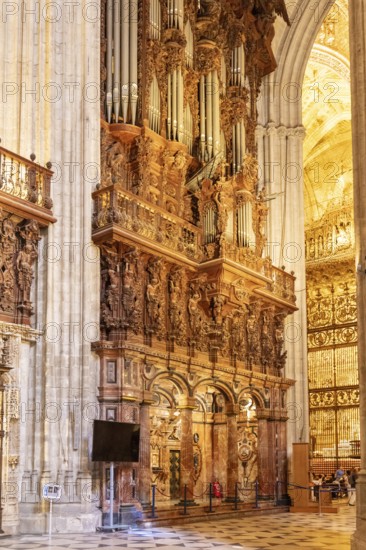 Magnificent organ in the interior of a cathedral with ornate decorations, Seville