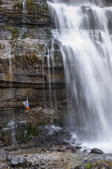 Little hiker in front of large Cascata di Mezzo waterfall, long exposure, Vallesinella, Brenta, Trentino, Italy