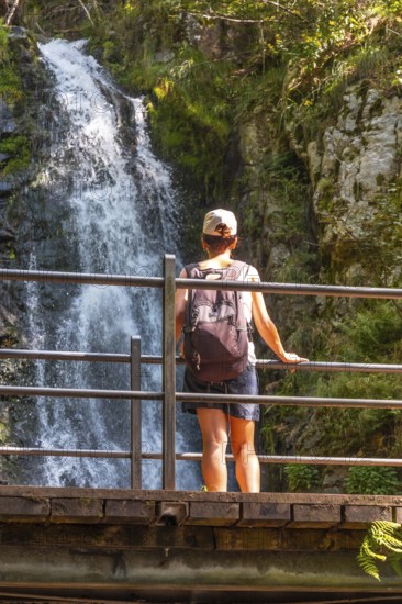 A woman at the top of the Todtnau waterfall in the Black Forest in Germany