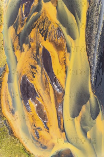 Stunning aerial shot captures the rich, golden hues of rivers snaking through the rugged terrain of Iceland, showcasing nature's artistry from above