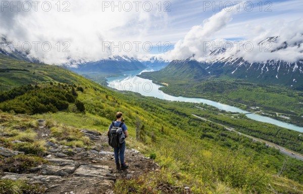 Climbers on a hiking trail, Slaughter Ridge Trail, view of snowy mountains and turquoise lake Kenai Lake, Cooper Landing, Kenai Peninsula, Alaska, USA