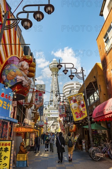 Lots of colorful signs in a pedestrian zone with shops and restaurants, behind Tsutenkaku Tower, Shinsekai, Osaka, Japan