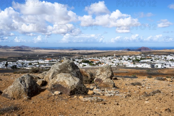 View of town, white houses of Teguise with church tower in dry volcanic landscape, view from Guanapay volcanic crater, Lanzarote, Canary Islands, Spain