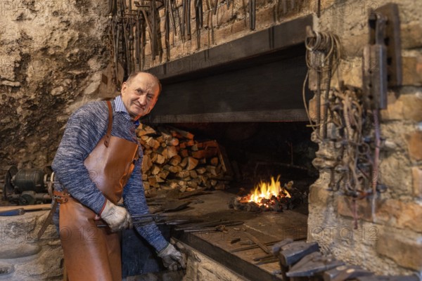 In a Salzburg workshop, an elderly blacksmith diligently upholds age-old blacksmithing traditions. His craft, rooted in centuries of history, keeps the art alive in Austria