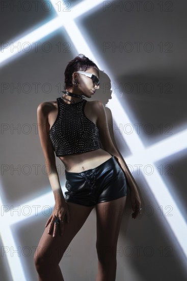 A stylish cyberpunk woman model in edgy fashion poses against a high-tech, modern backdrop. The futuristic scene evokes a sense of bold, urban adventure