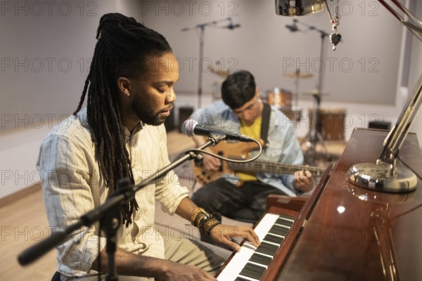 Musicians engage in an inspiring recording session with a pianist and guitarist in a professional studio, surrounded by high-quality equipment and warm lighting