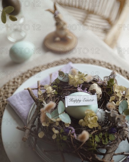 Top view of an elegantly arranged Easter table setting featuring naturally dyed eggs nestled in a decorative nest with spring flowers and a tag reading Happy Easter