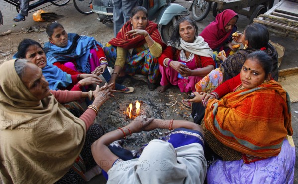 New Delhi, India, 15.01.10 - Women warm up by a fire at the market in New Delhi, India