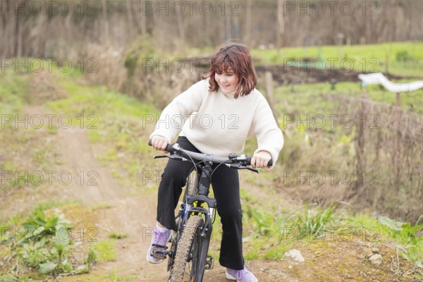 A young girl enjoys biking on a dirt trail, surrounded by greenery. She wears a cozy sweater and has a joyful expression, embodying adventure and outdoor fun