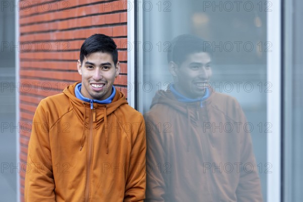 A person reflects calmly while leaning against a window at a mental health leisure center. Their serene expression conveys peace and relaxation, representing a supportive environment