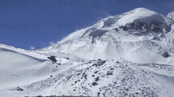 Snowy mountain landscape under clear blue sky, Thorong La, Manang, trekking at Annapurna Circuit, Nepal
