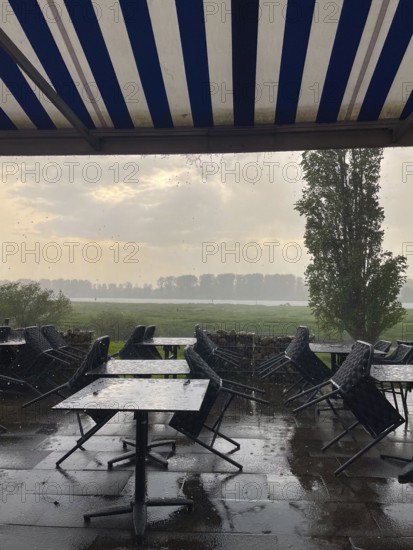 Thunderstorm and raindrops on a terrace of a restaurant on the Rhine in Düsseldorf, Germany