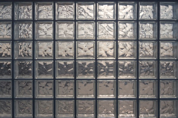 Aesthetic and modern design of textured glass block wall, capturing abstract patterns and light distortions. The photo was taken in Valdebebas, a major transport hub in Madrid
