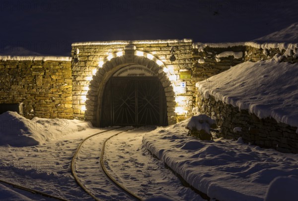 Illuminated mouth hole from Markus-Röhling-Stolln visitor mine in the snow, historical origin to the Lichterbogen, Frohnau, Annaberg-Buchholz, Ore Mountains, Saxony, Germany