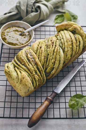 Baked homemade savoury babka plaited bread loaf flavoured with pesto