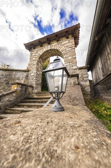 Historic stone arch with staircase and lantern in the foreground, Lake Brienz, Switzerland