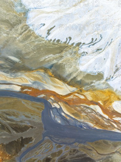 Top view aerial shot capturing the enticing swirls and organic patterns formed by natural elements. The dynamic array of colors and textures offers a unique perspective on the landscape's beauty