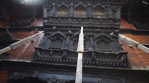 Detailed view of artfully carved facades, Kumari Ghar at Durbarsquare in Kathmandu with detailed historic building facades and secured from collapse with wooden supports after the earthquake, Kathmandu, Nepal