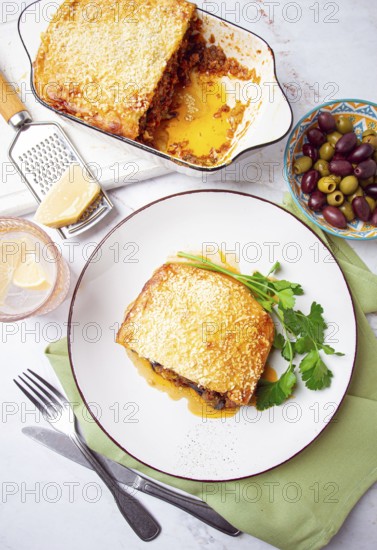 Moussaka served with olives, in a bright kitchen setting, homemade, no people