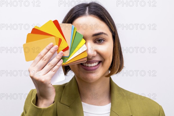 A smiling woman holds a vibrant palette of color swatches, signifying a professional image consultation. She wears a green blazer, indicating her expertise in style advice