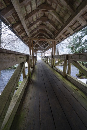 Long walkway of a wooden bridge over a wintry river course, Kälberbrücke, Enzklösterle, Calw district, Black Forest, Germany