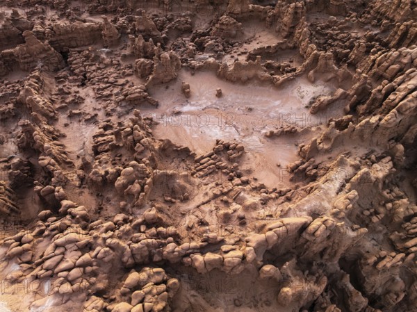 A captivating aerial shot of the textured, rocky formations at Goblin Valley State Park, Utah, showcasing erosion patterns and sediment layers