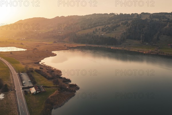 Valley with quiet lake and surrounding landscape in the warm light of sunset, Großer Alpsee, Immenstadt im Allgäu, Bavaria, Germany
