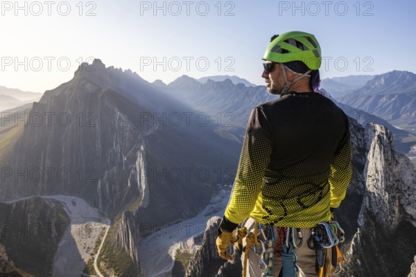 A man pauses to rest while mountaineering and rappelling in Eagleâ€™s Nest, Monterrey, Mexico, showcasing the breathtaking view of the mountainous landscape