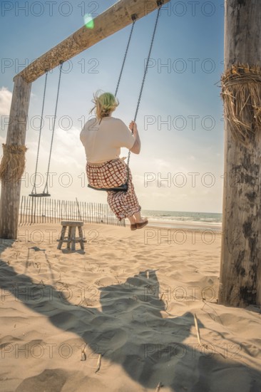 Tourist on the beach on a swing, Zandvoort, Netherlands