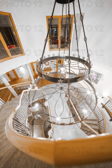 Impressive spiral staircase with decorative chandelier and wooden details, Hotel Krone Lamm, Zavelstein, Black Forest, Germany