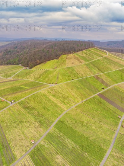 Aerial view of green fields and roads in hilly terrain under a cloudy sky, Großbottwar, Ludwigsburg district, Baden-Württemberg, Germany