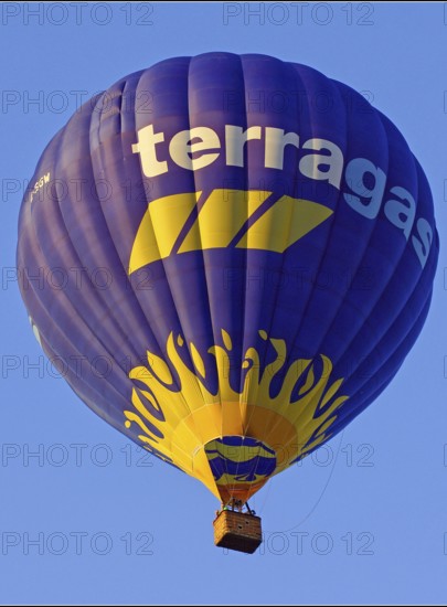 A flying hot air balloon, inscription: terragas, Montgolfiade, yellow, blue, Austria