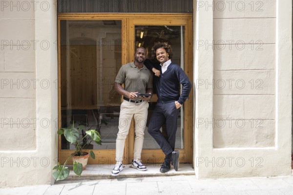Two professionals smiling in front of a coworking space in Barcelona, showcasing a modern and collaborative work environment. Perfect for networking and creativity in a vibrant city
