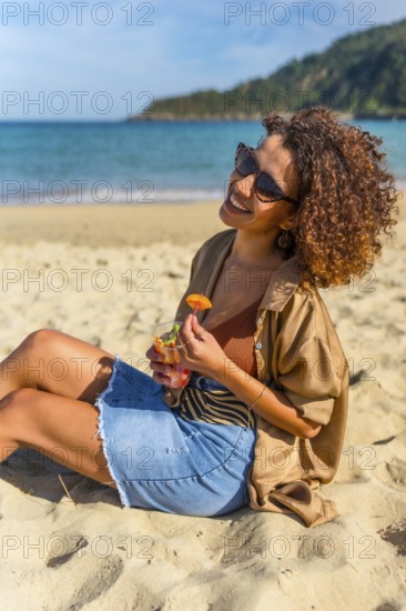 Arab modern young woman enjoying daydreaming on the beach sunbathing and eating tropical delicious fruit