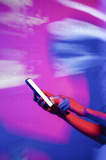 A hand interacts with a smartphone illuminated by vibrant neon lights, creating a modern and futuristic atmosphere. The glowing neon hues highlight the digital connectivity