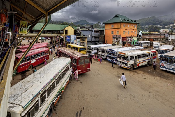 Several buses at a bus stop with people and mountainous landscape in the background, Nuwara Eliya Sri Lanka Bus Station