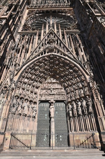 Strasbourg, France, September 2023: Gothic style entrance door with tympanum of west facade of famous Strasbourg Cathedral in France