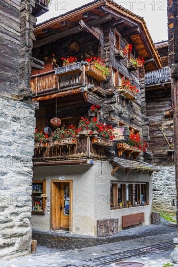 Old house decorated with flowers in the historic village centre, Grimentz, Val d'Anniviers, Valais Alps, Canton Valais, Switzerland