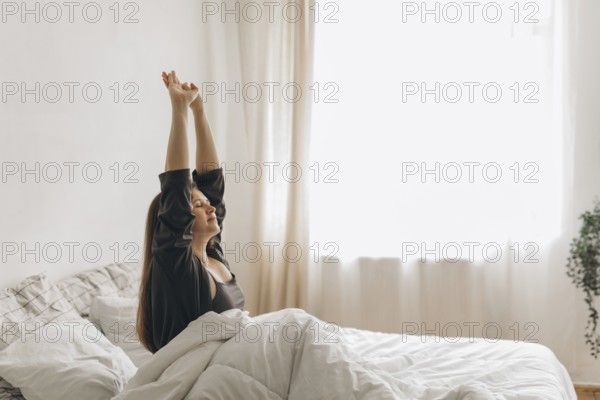 A woman stretches in bed, bathed in soft morning light, symbolizing a fresh start. The peaceful scene inspires health and wellness, perfect for a nutritionist theme