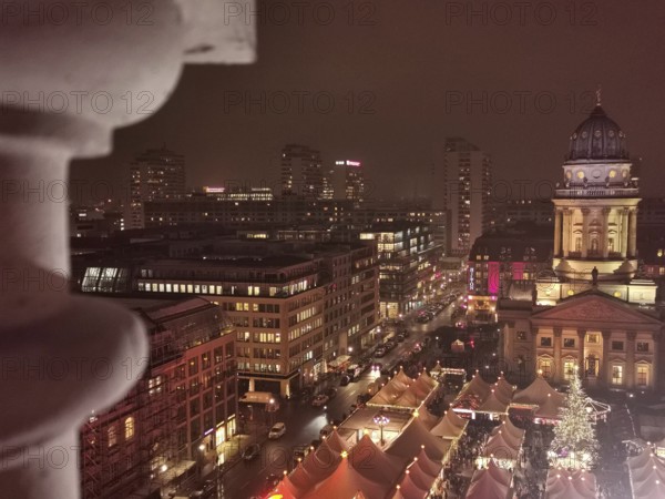 Night view over the roofs of the Christmas market on the Gendarmenmarkt of the festively illuminated city of Berlin