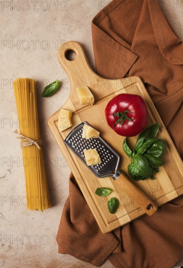Raw pasta with ingredients on a beige background, top view, rustic style, selective focus, no people