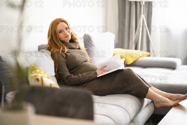 A pregnant woman sits comfortably on a cozy couch, enjoying a relaxing moment with a captivating book. The warm and inviting atmosphere suggests tranquility and peace