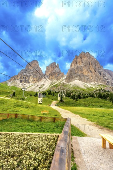 Cable cars transporting tourists up the scenic sella pass in the dolomites, italy, during a beautiful summer day