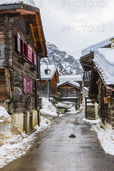 Street with historic old snow-covered wooden houses, mountain village of Zinal, Val d'Anniviers, Valais Alps, Canton Valais, Switzerland
