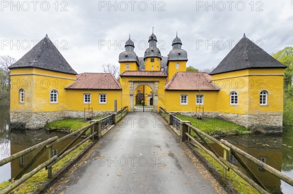 Schloss Holte, Schloss Holte-Stukenbrock, North Rhine-Westphalia, Germany, Baroque yellow castle, hunting lodge with towers and moat under a grey sky