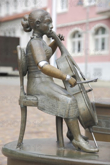 Cello player at the Musicians' Fountain by Bonifatius Stirnberg 1989, cello, stringed instrument, making music, female figure, musician, music, cello player, sculpture, bronze, chair, sitting, Donaueschingen, Southern Black Forest, Black Forest, Baden-Württemberg, Germany